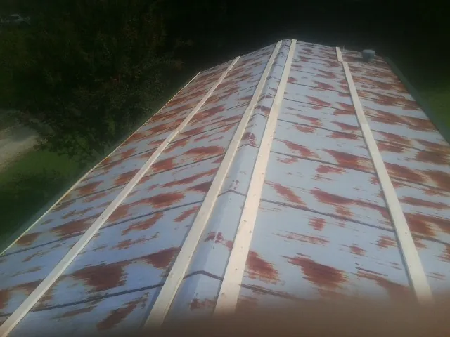 Rusted metal roof panels with new wood purlins before replacement — Storm Damage Roof Repair in Petros by Roofing Brothers