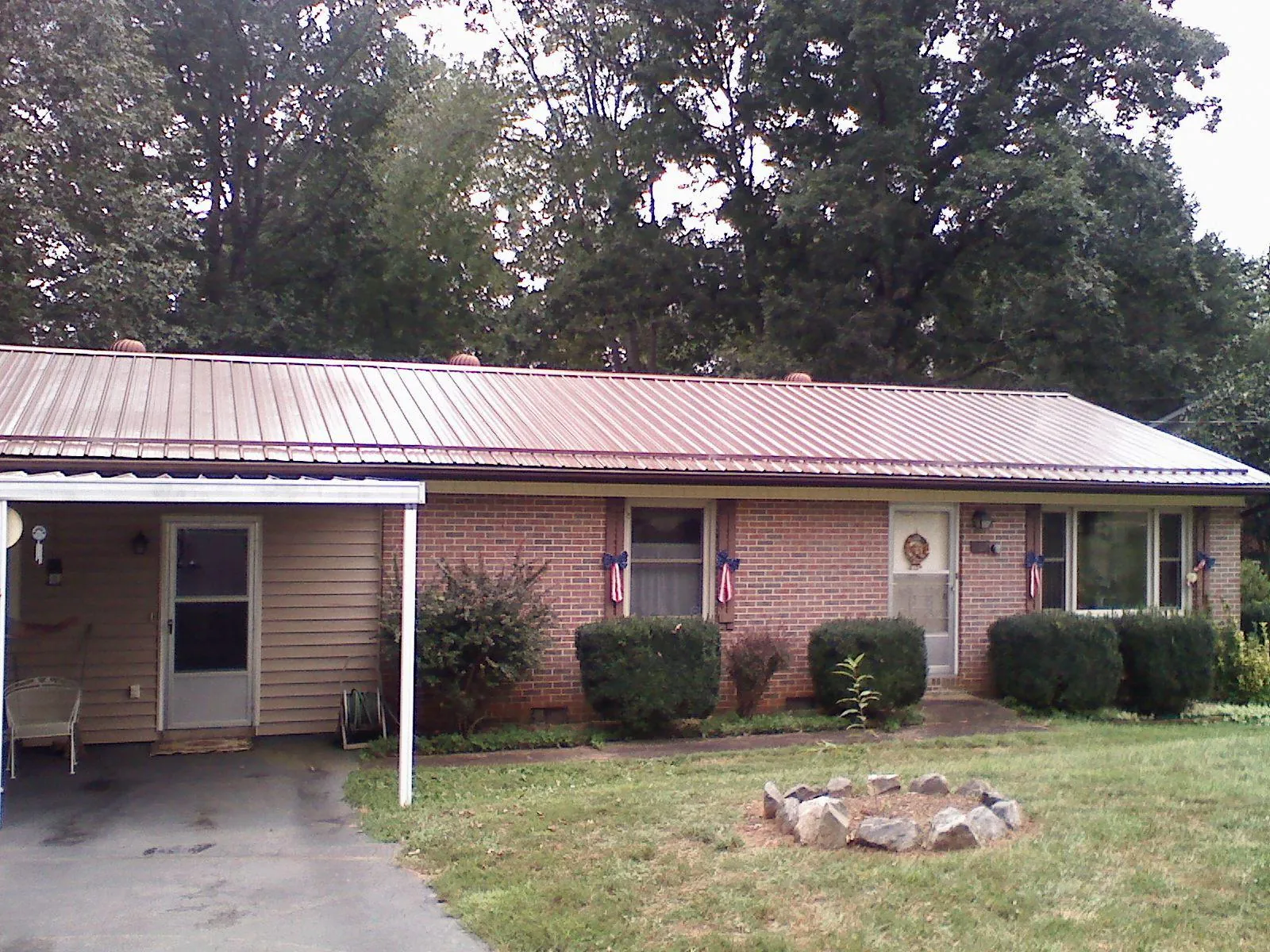Bronze metal roof and carport on a brick ranch home — Roof Repair work by our crew in Petros